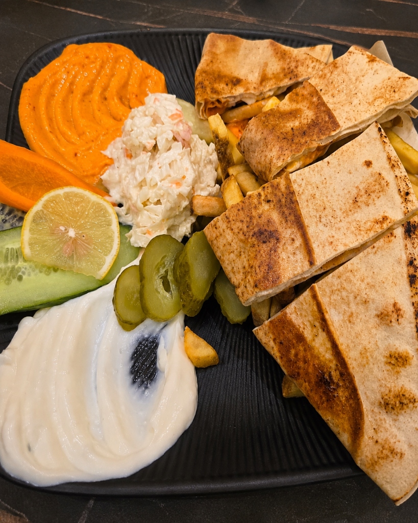 Teller mit Beilagen bei Shawarma Albaik Berlin: Knoblauchsauce, Cocktailsauce, Krautsalat, Pommes und gebackenes Fladenbrot