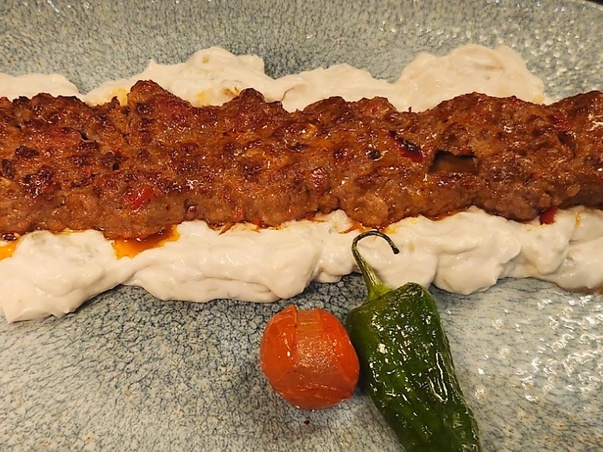 Nazik Ali bei Baba Pirzola Berlin: Gegrillter Hackfleischspieß aus Lamm- und Kalbsfleisch auf geröstetem Auberginenpüree in Joghurt-Butter-Knoblauchsoße