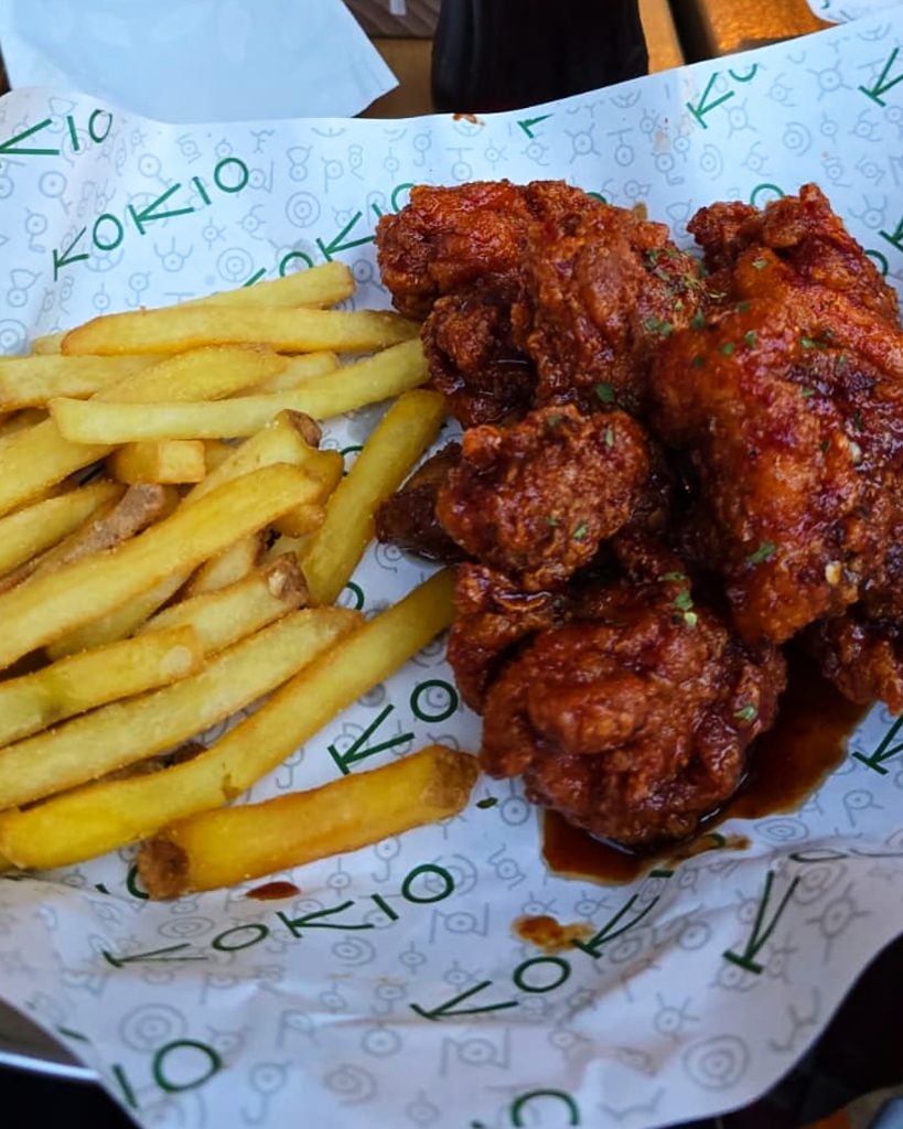 Knuspriges Fried Chicken mit Sauce und klassischen Pommes bei KOKIO Berlin