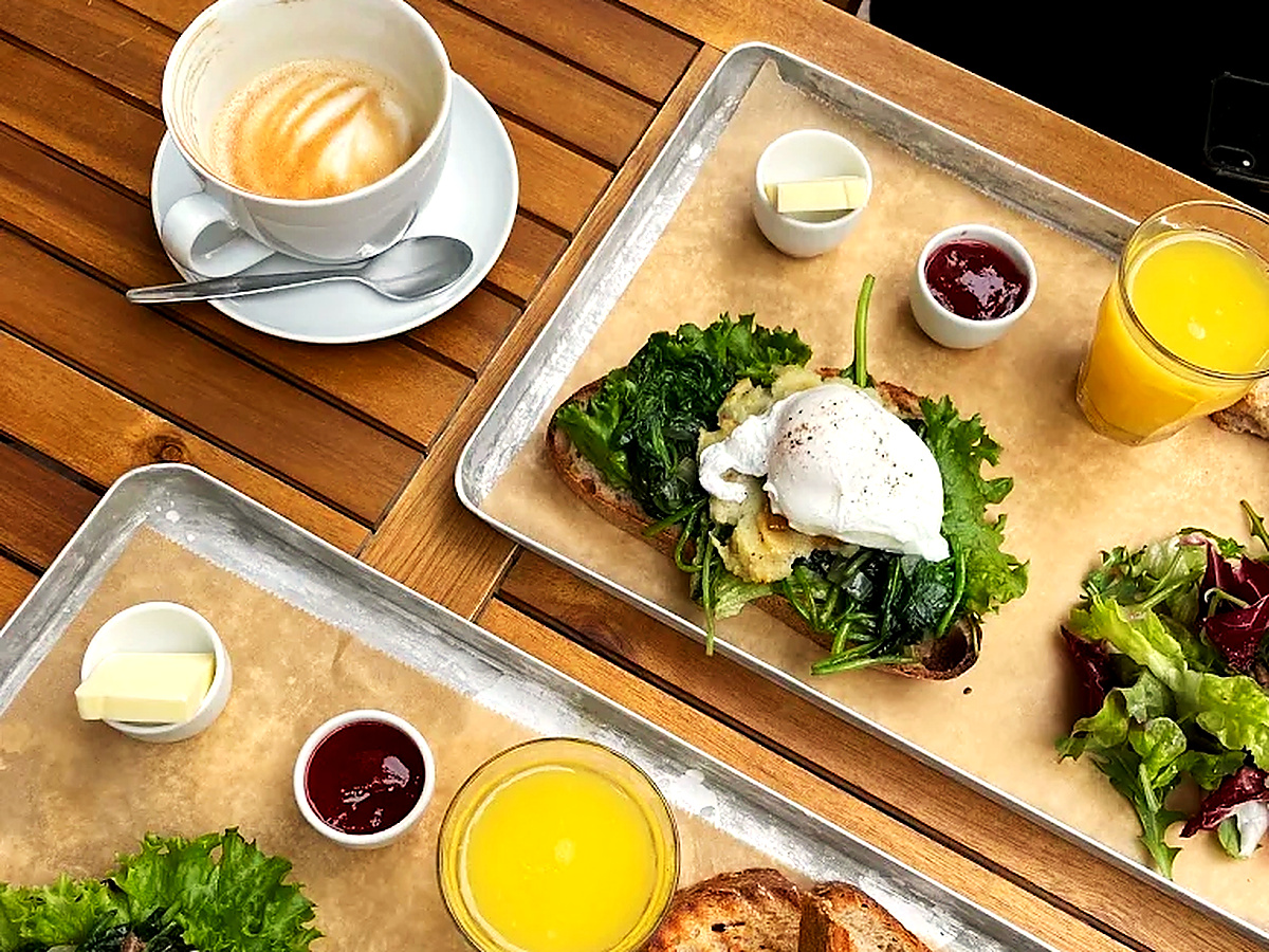 Frühstück im Neumanns Café Berlin-Friedrichshain: Pochierte Eier auf jungem Blattspinat und Sauerteigbrot mit frisch gepresstem Orangensaft und Cappuccino